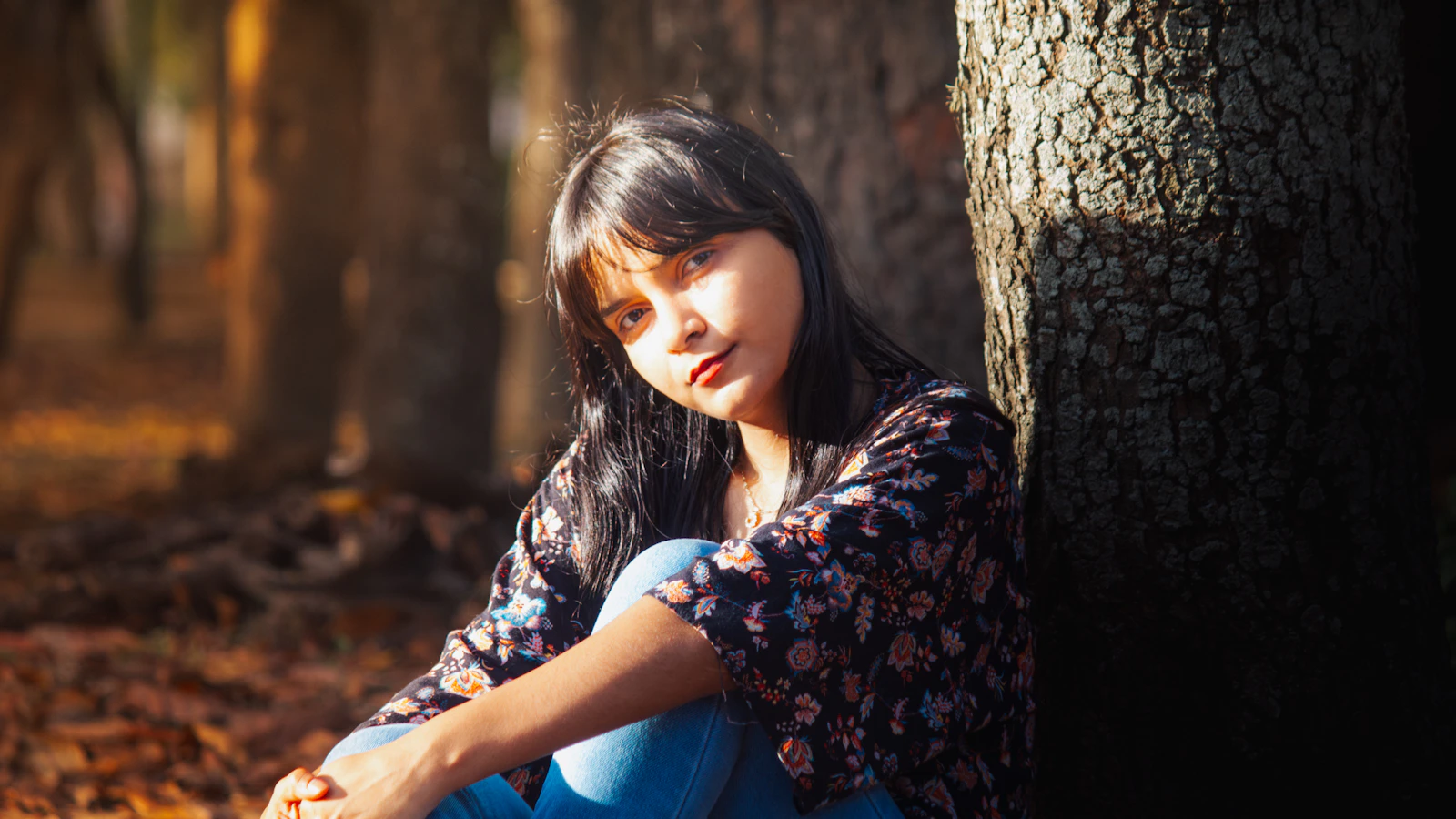 A woman sitting quietly outdoors among the trees